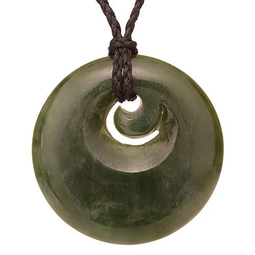 Greenstone necklace featuring a 40mm jade disc with small Koru, symbolizing new beginnings, on a black wax cord.