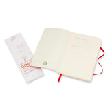 Scarlet red Moleskine notebook with soft cover, plain pages, elastic closure, and bookmark, perfect for portable creativity.