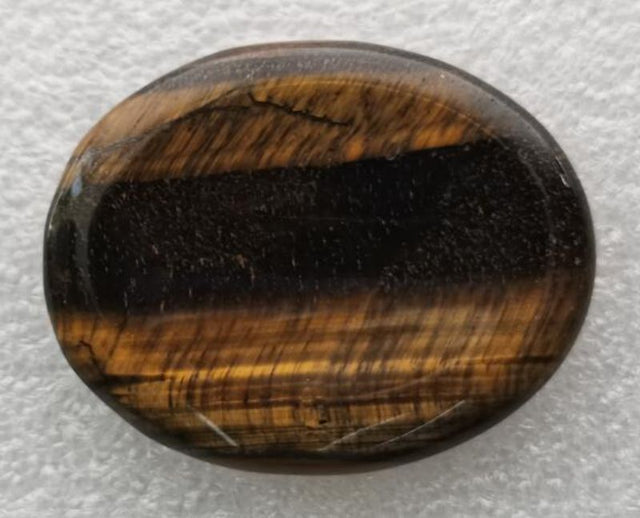 Smooth oval Tiger Eye worry stone (4.5cm) for stress relief, meditation, and emotional balance with golden-brown stripes.