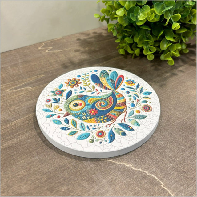 Small canvas circle featuring a blue patchwork bird design, ready to hang for colorful home decor.