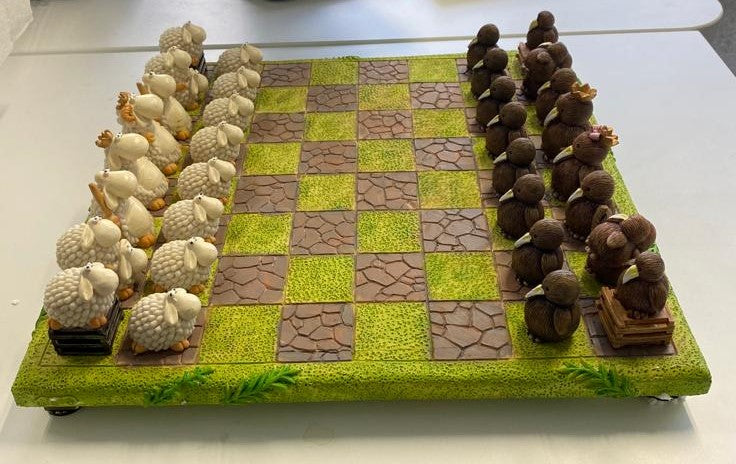 Sheep vs Kiwi Chess Set featuring unique sheep and kiwi pieces on a lush green board, perfect for strategy and cultural charm.
