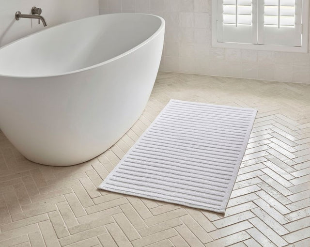 Nova Luxury Double Bath Mat in optic white, 100% cotton, with a soft striped texture, measuring 60 x 120cm.