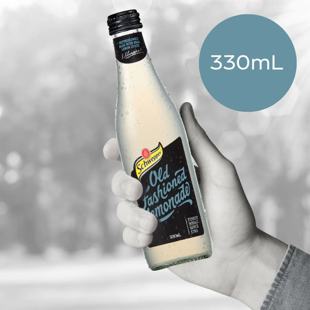 Schweppes Traditional Lemonade with 5% real lemon juice, refreshing and zesty in classic glass bottle packaging.