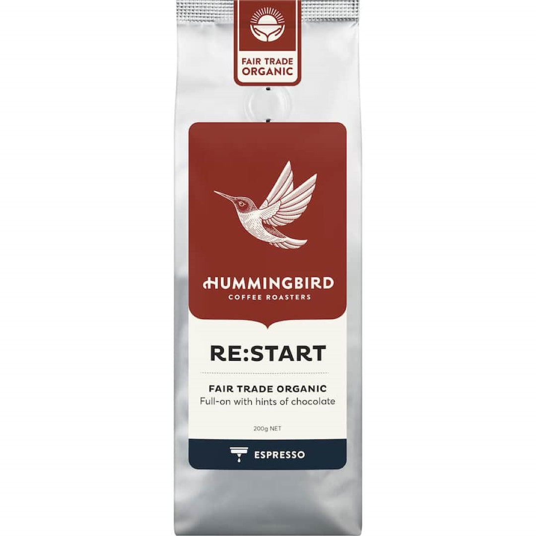 Freshly roasted Hummingbird Fair Trade Organic Espresso Grind Coffee, showcasing nutty, chocolaty flavors in a 200g package.