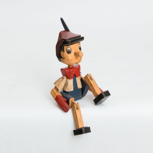 Small Pinocchio Sitting Ornament, intricately detailed with expressive features, perfect for whimsical home decor or as a gift.