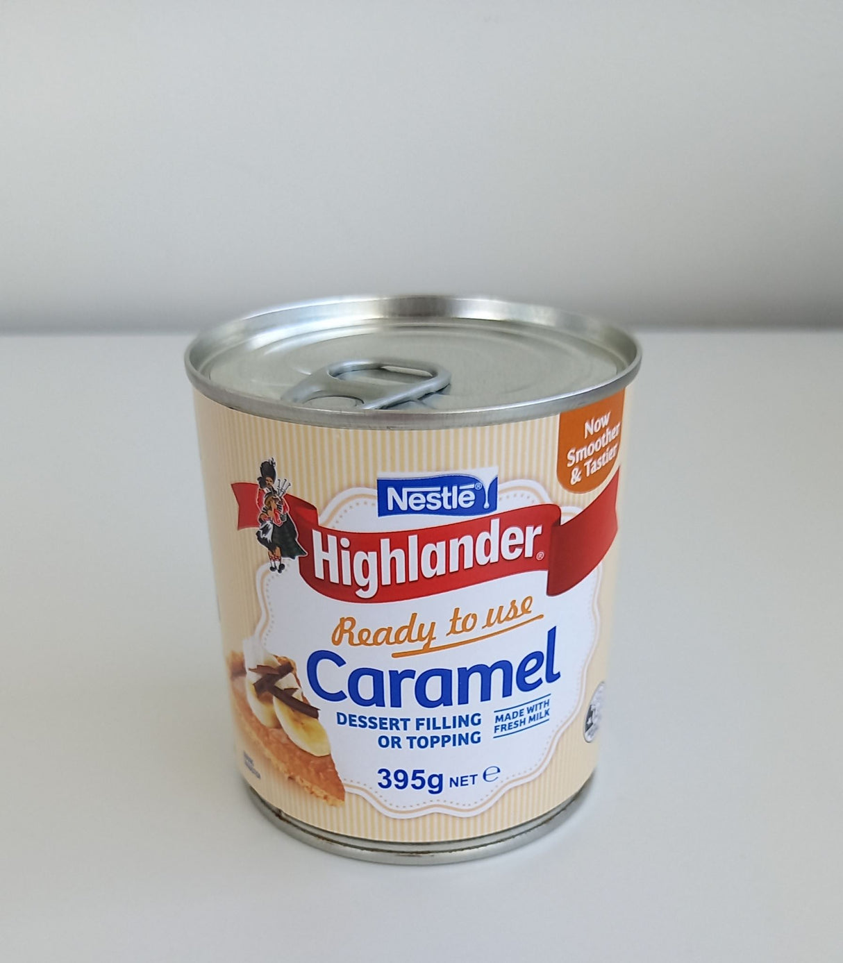 Tin of Highlander Milk Condensed Caramel, 395gm, featuring rich, creamy sweetness perfect for desserts and coffee.