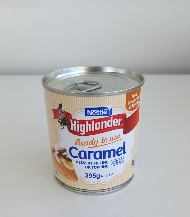 Tin of Highlander Milk Condensed Caramel, 395gm, featuring rich, creamy sweetness perfect for desserts and coffee.