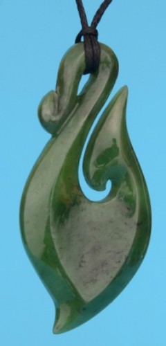 Stylized greenstone hook pendant on adjustable cord, featuring unique carvings and a presentation box.