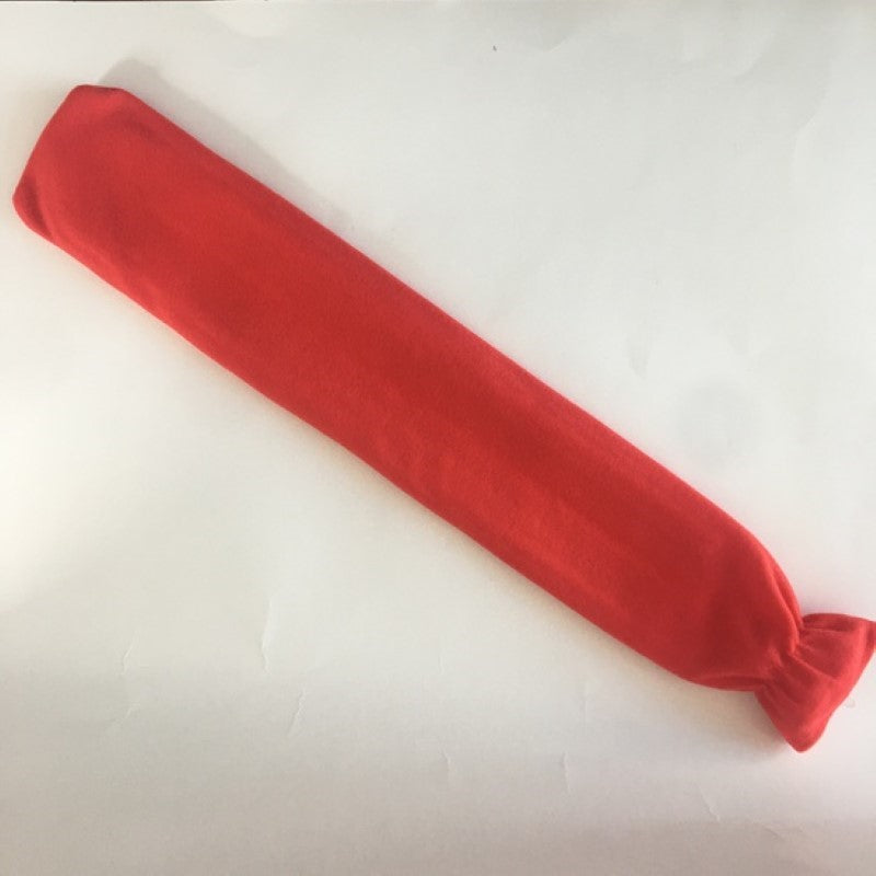 Long red hot water bottle with soft fleece cover for comfort, ideal for soothing aches and keeping warm during chilly nights.