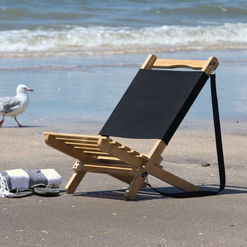 Wave Beach Chair: Foldable bamboo chair with black canvas backrest, lightweight, portable, perfect for beach outings.