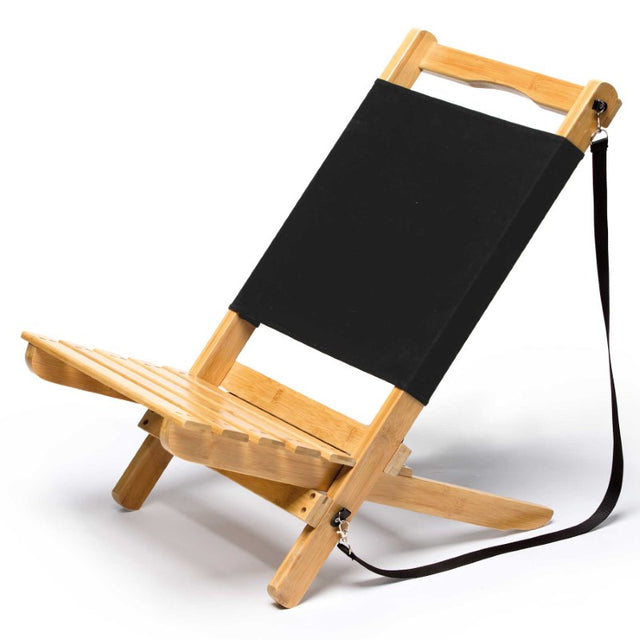Lightweight foldable Wave Beach Chair made of sustainable bamboo, featuring a black canvas backrest and detachable shoulder strap.