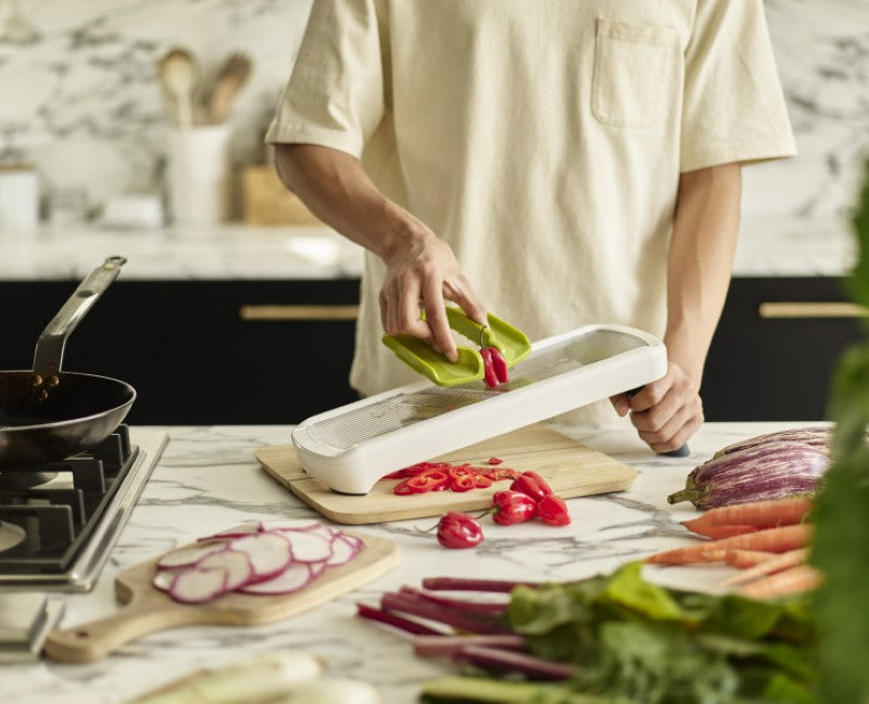 Joseph Joseph Multi-Grip Mandoline Plus with adjustable thicknesses and safety grip for slicing fruits and vegetables efficiently.