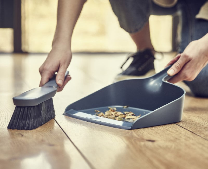 Joseph Joseph CleanStore Dustpan & Brush with wall-mounted holder, feathered bristles, and rubber edge for efficient cleaning.