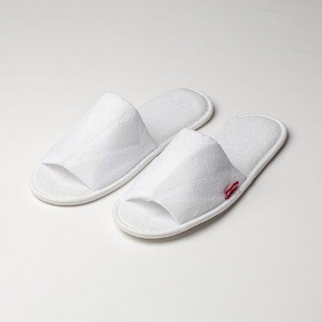 Open toe cotton slippers in white terry, padded for comfort, with rubber soles for non-slip safety; perfect for relaxation at home.
