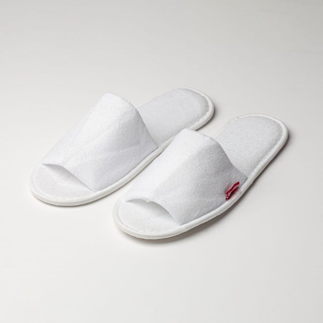 Open toe cotton slippers in white terry, padded for comfort, with rubber soles for non-slip safety; perfect for relaxation at home.