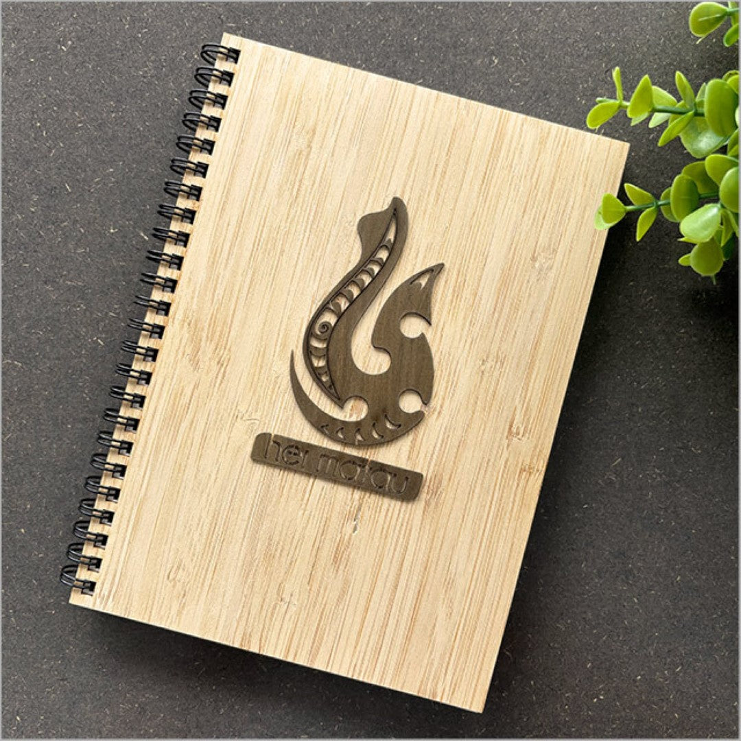 Small bamboo journal with Rimu veneer, featuring Hei Matau motif, perfect for writing, sketching, or traveling.