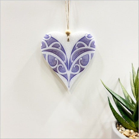 Heart-shaped hanging ornament in vibrant designs, crafted from thick satin acrylic, perfect for home decor or gifting.