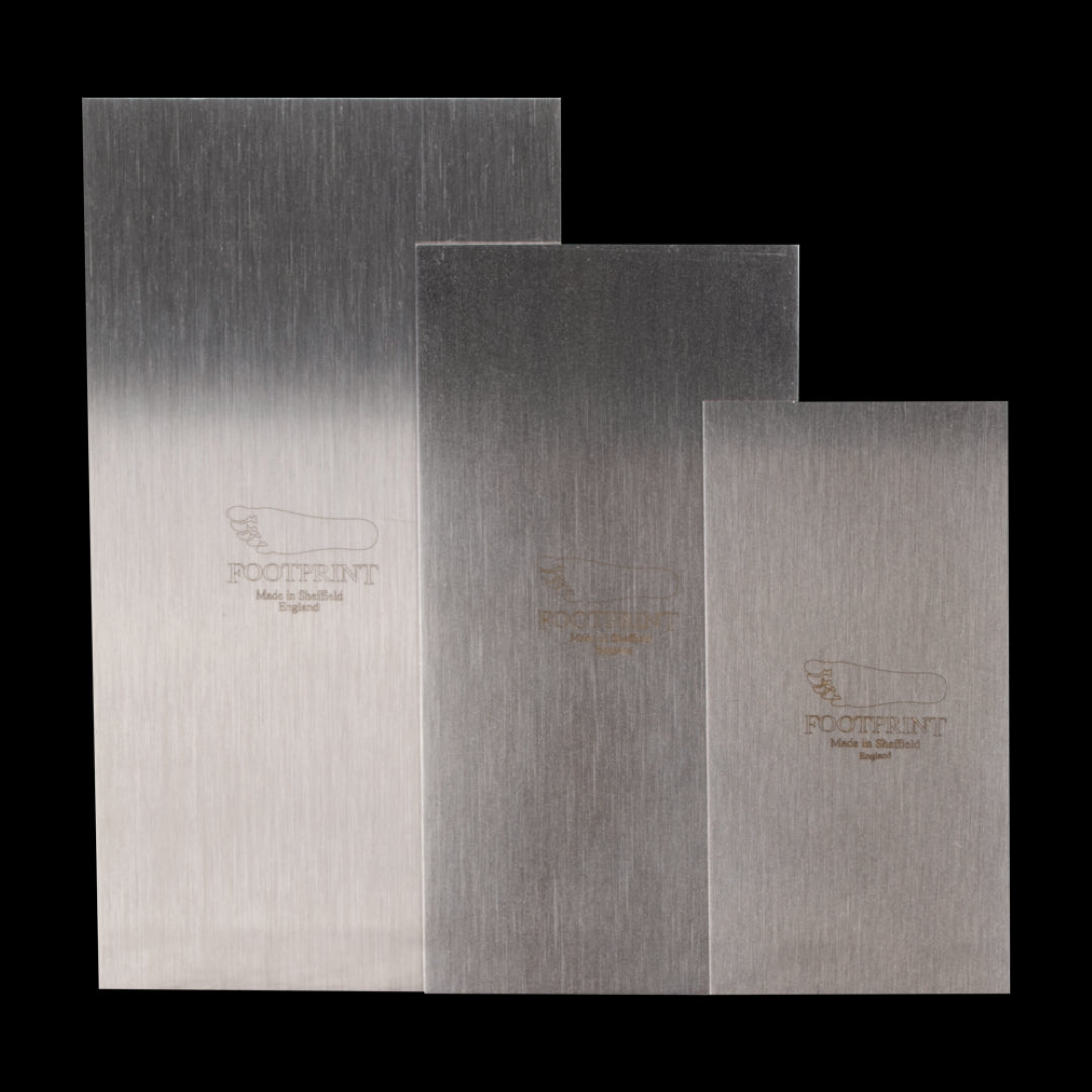Set of three Footprint Cabinet Scrapers made from high carbon spring steel for precise wood shaping and finishing.