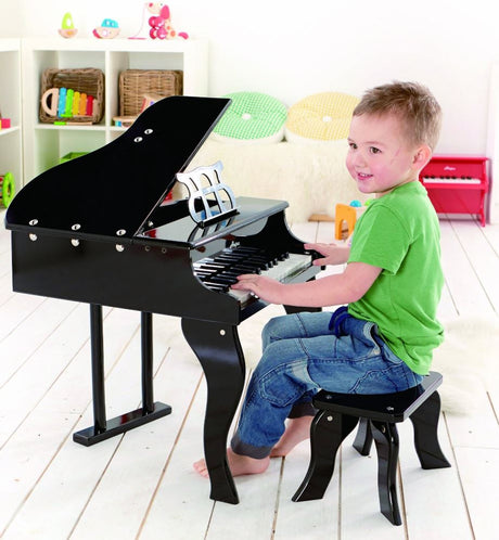 Colorful Hape grand piano with 30 keys, openable lid, made from sustainable wood, ideal for young musicians.