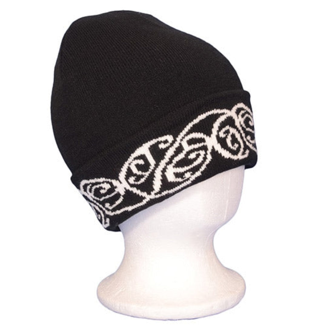 Black beanie featuring a bold white embroidered M?ori pattern, perfect for warmth and style in cooler weather.