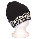 Black beanie featuring a bold white embroidered M?ori pattern, perfect for warmth and style in cooler weather.