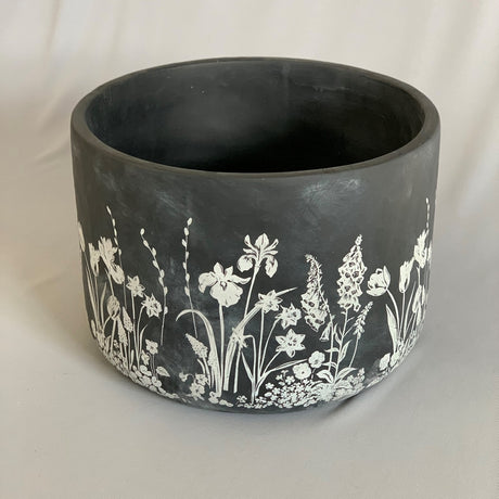 Elegant black planter with blooming flowers, perfect for indoor or outdoor use, measuring 24 x 18cm.