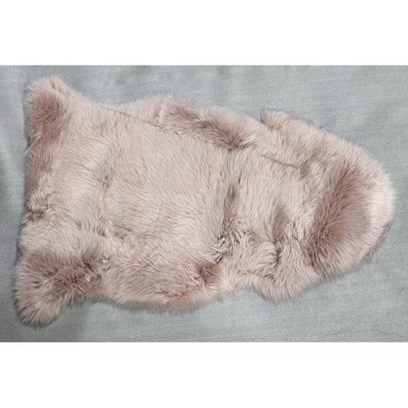 Soft rose-colored NZ sheepskin rug (60x90cm) adds warmth and elegance, perfect for draping or enhancing any space.