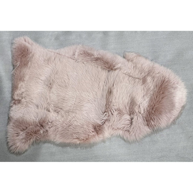 Soft rose-colored NZ sheepskin rug (60x90cm) adds warmth and elegance, perfect for draping or enhancing any space.