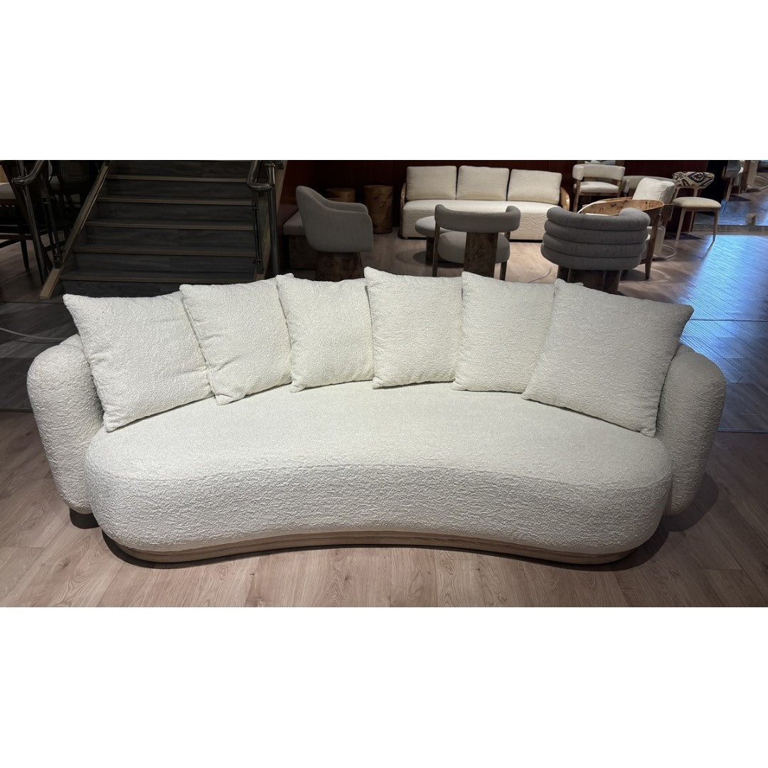 Elegant curved sofa in Oberoy linen and burl walnut, featuring plush cushioning and a stylish design for modern homes.