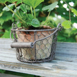 "Set of 2 terracotta pots in wire baskets with handles, perfect for rustic home décor and plant display."