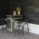 Grey Tractor Bar Stool showcasing vintage design, height adjustable, sturdy with footrest for comfort in any space.