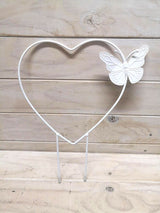 Heart-shaped metal garden stake with a butterfly design, providing support for plants and enhancing outdoor decor.