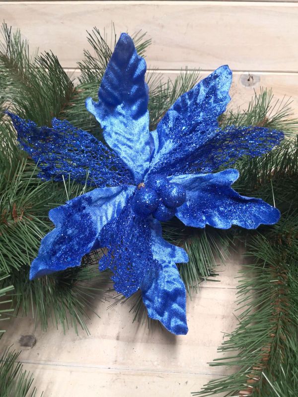 Vibrant blue metal and mesh poinsettia flower decoration for festive indoor or outdoor holiday decor.