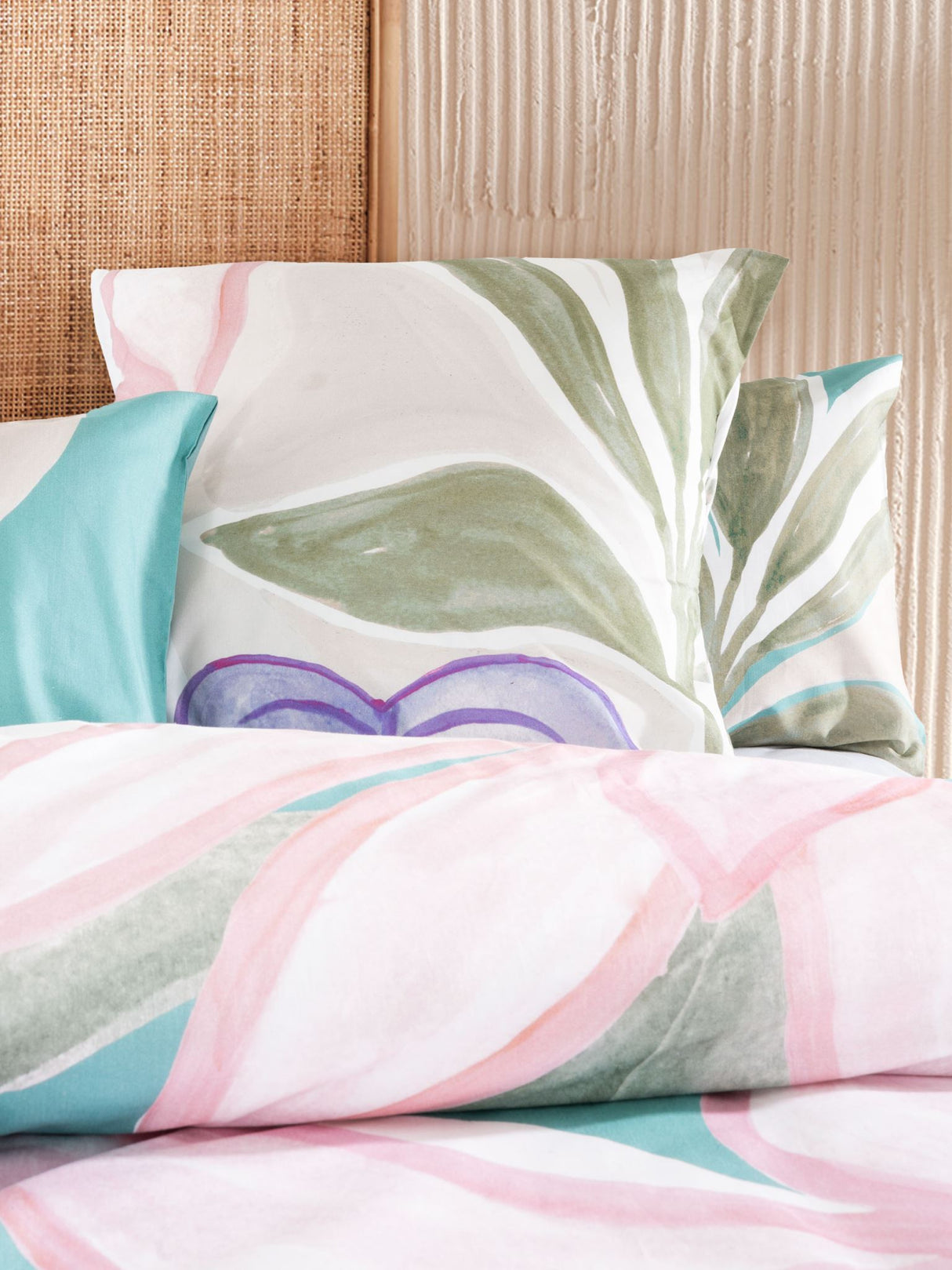 Super King duvet cover set featuring vibrant hand-painted tropical foliage on a turquoise base, crafted from 100% cotton slub.