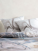 Super King Duvet Cover Set featuring a marble design in cotton sateen, with teal accents and includes pillowcases.
