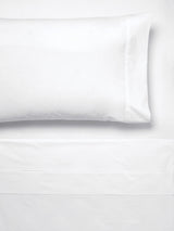 Elegant white king sheet set made of 300T cotton percale, featuring cuffed pillowcases and a 45cm fitted sheet wall.