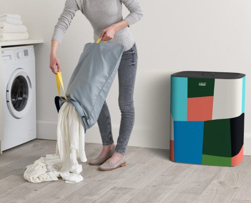 Stylish Tota 90L laundry basket with dual compartments and removable tote bags for easy fabric separation and transport.