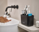 Sleek black toothbrush caddy with multiple compartments for organized storage and easy cleaning, ideal for modern bathrooms.