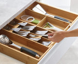 Bamboo kitchen drawer organiser with five cutlery compartments, two gadget spaces, and expandable sides for neat storage.