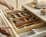 Bamboo drawer organizer with five cutlery compartments and two gadget slots, expandable to fit various drawer sizes.