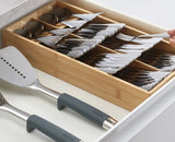 Bamboo cutlery organizer with overlapping compartments, icons for easy access, and non-slip feet to maximize drawer space.