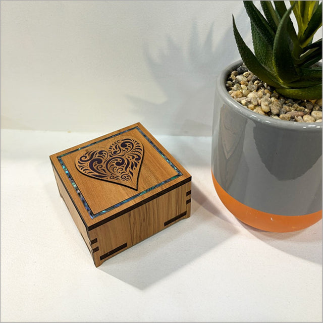 Elegant small square trinket box with a paua inlay and intricate filigree design, perfect for storing keepsakes and jewelry.