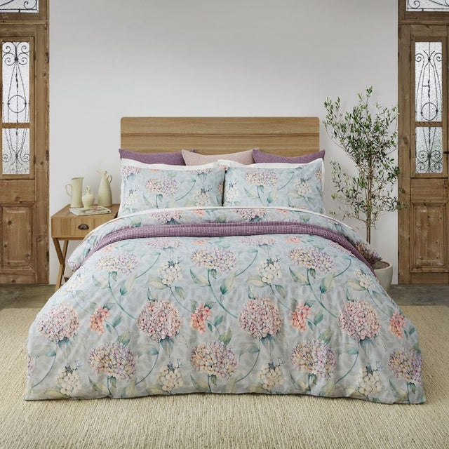 Duvet cover set featuring soft hydrangea florals in pink and purple on green, made from 100% OEKO-TEX® cotton.