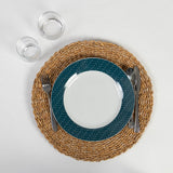 Handmade round seagrass placemat, 400mm diameter, adding coastal charm and durable protection for dining tables.