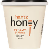 Hantz Clover Honey Creamy in a jar, showcasing its pale color and thick texture, perfect for sweetening dishes and baking.