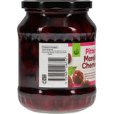 A jar of Woolworths Morello Cherries in syrup, showcasing their vibrant red color and luscious, juicy appearance.