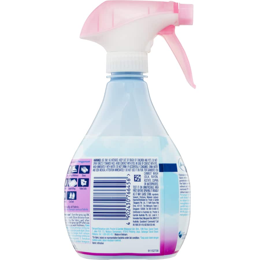 Spray bottle of Febreze Fabric Freshener Blossom & Breeze for deep odor elimination and fresh floral scent in fabrics.