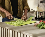 Folding green chopping board with non-slip feet, knife-friendly surface, and easy-transfer chute for mess-free food prep.