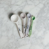 Set of 4 Mason Cash In The Forest Measuring Spoons in pastel shades, featuring embossed forest designs for precise cooking.