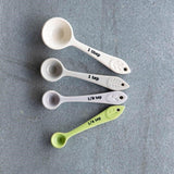 Pastel-colored, chip-resistant stoneware measuring spoons set of 4, featuring forest-inspired designs for stylish cooking.